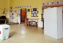 Komunální volby 9. a 10. října, do kolika se volí a co s sebou Volební místnost ve třídě základní školy s bílou volební urnou a plentou
