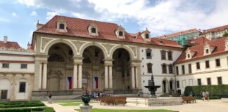 Kdo kandiduje do Senátu ve 27 obvodech a kdo obhajuje mandát Sala terrena Valdštejnského paláce v Praze, sídla Senátu, s českými vlajkami a kašnou v zahradě